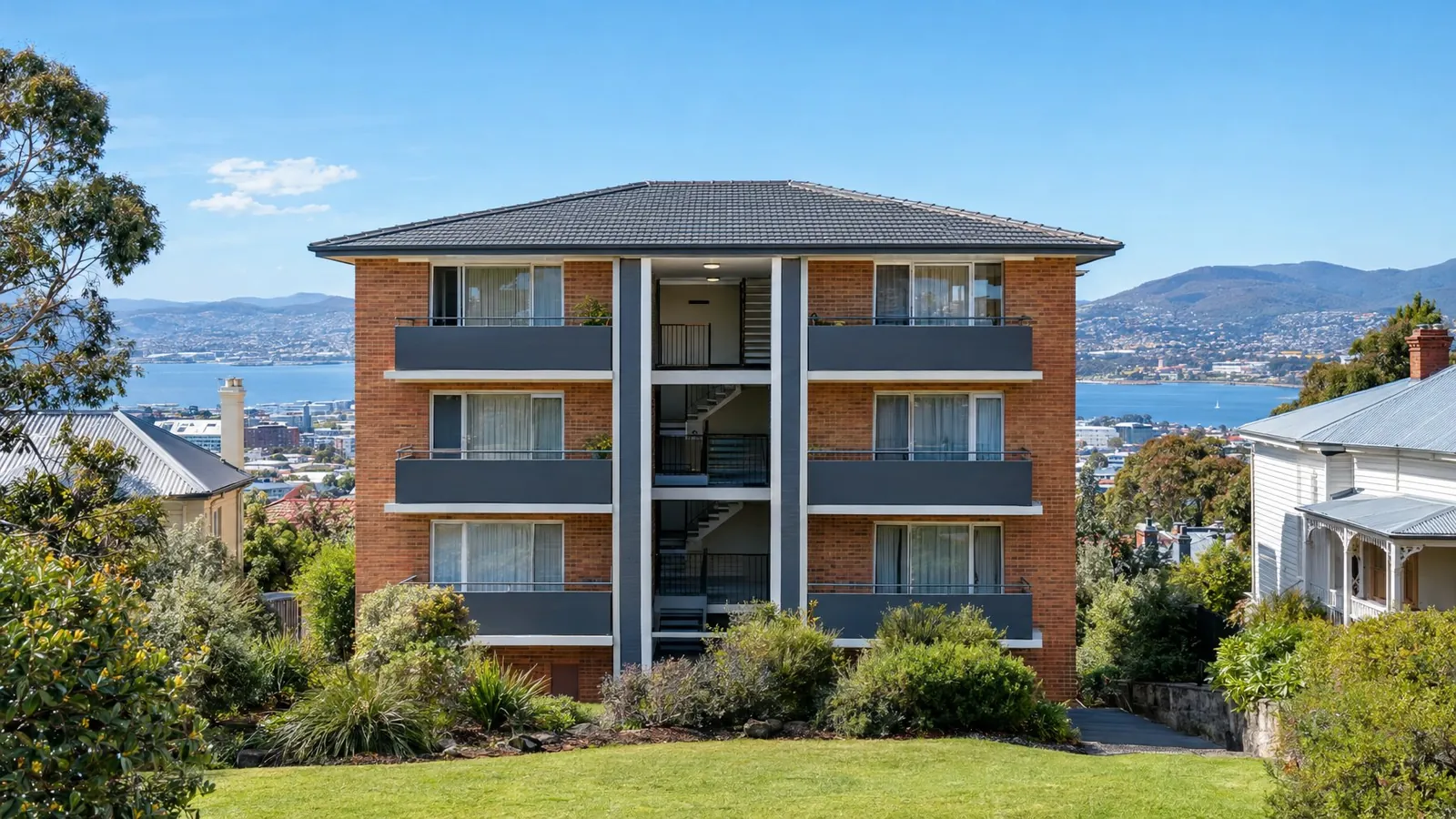 A low-rise brick apartment block with freshly painted balconies and stairwell.